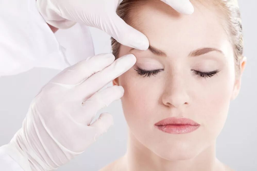 De cosmetoloog onderzoekt de huid rond de ogen
